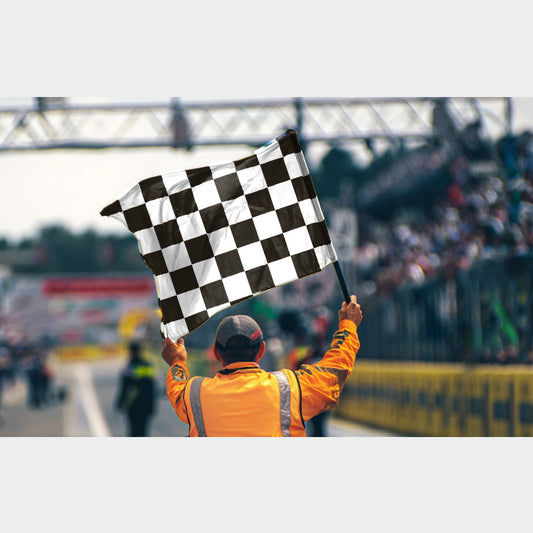 Drapeau à damier noir et blanc brandi à l’arrivée d’une course automobile
