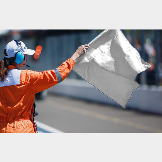 Commissaire de course signalant un véhicule lent avec un drapeau blanc