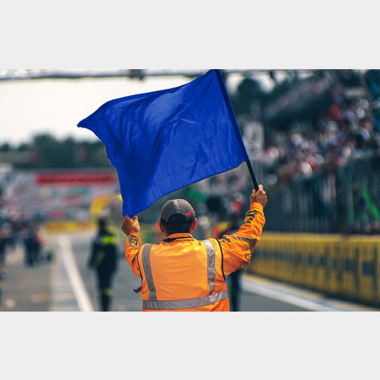 Drapeau bleu levé par un commissaire – signal piste en sport auto ou karting