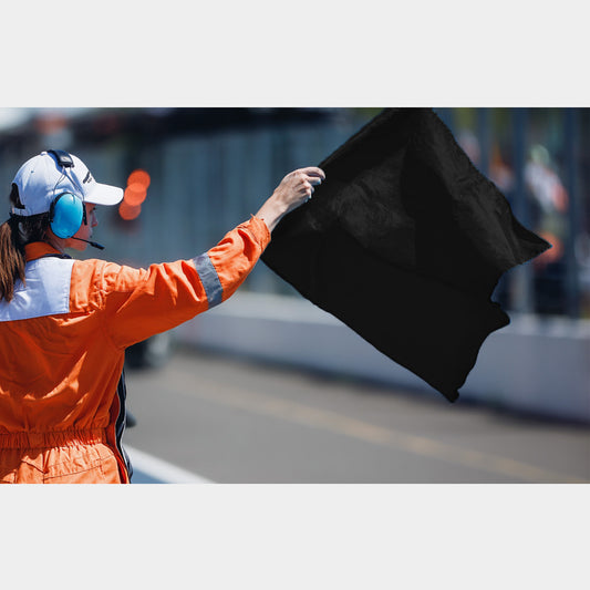 Commissaire de course brandissant un drapeau noir pour signaler une exclusion
