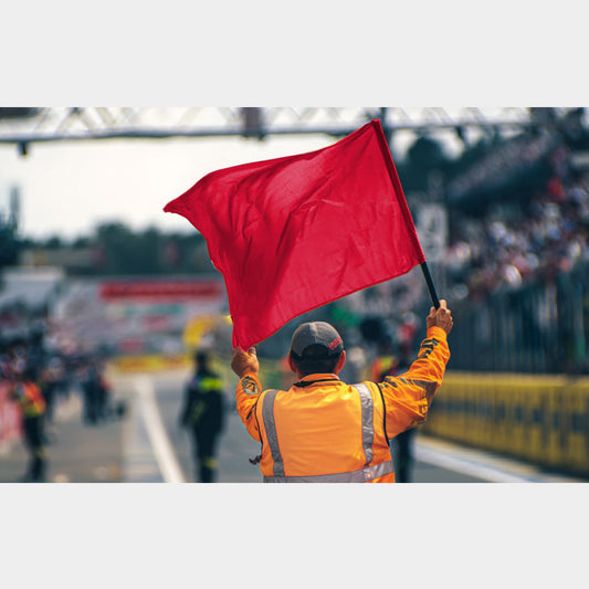 Drapeau rouge levé par un commissaire – signal  sur piste en sport auto ou karting