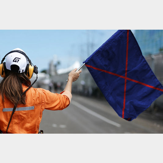 Drapeau bleu à croix rouge – utilisé en karting pour arrêter un pilote avant dépassement lors des repêchages